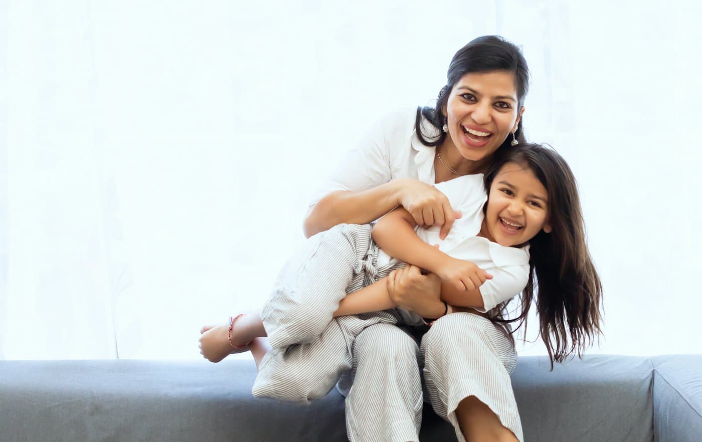 A mother hugging her laughing daughter